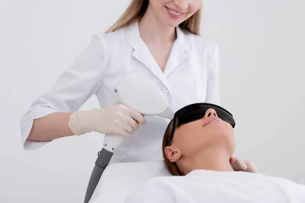 Частичный вид молодой женщины, получающей эпиляцию лазерной эпиляции на лице в салоне — стоковое фото