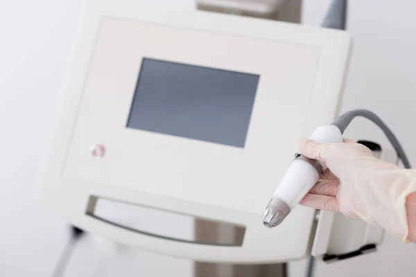 Partial view of cosmetologist and cosmetology apparatus in salon — Stock Photo