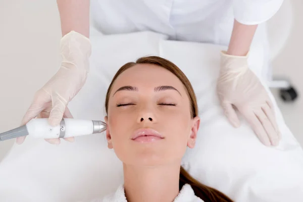 Partial view of woman getting facial treatment in cosmetology salon — Stock Photo