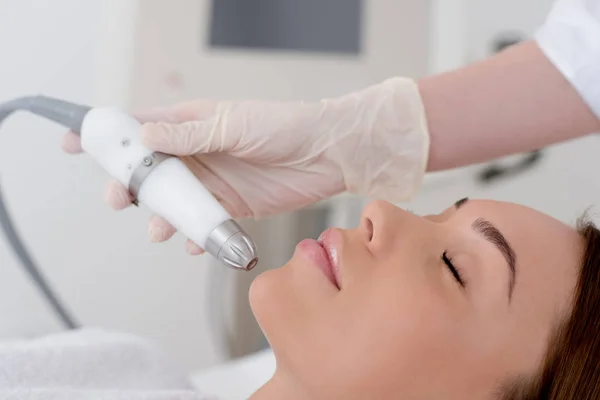 Partial view of woman getting facial treatment in cosmetology salon — Stock Photo