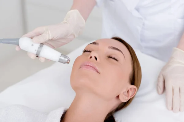 Partial view of woman getting facial treatment in cosmetology salon — Stock Photo