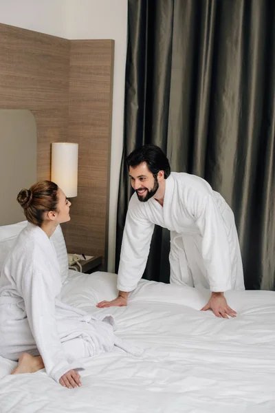 Hermosa pareja en albornoces coqueteando en suite de hotel - foto de stock