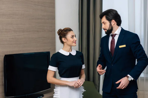 Personal de servicio de hotel joven hablando en suite - foto de stock