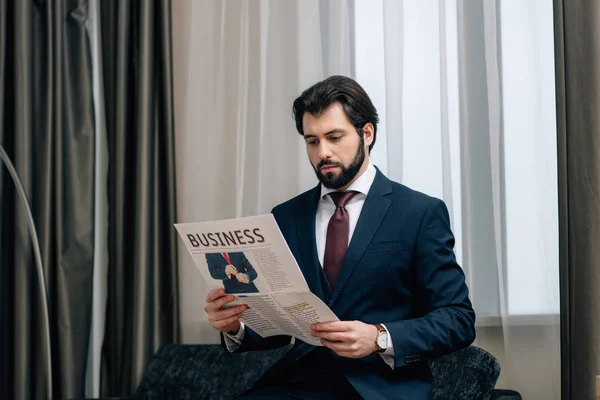 Uomo d'affari adulto che legge il giornale in camera d'albergo — Foto stock