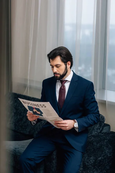Sério empresário ler jornal no quarto de hotel — Fotografia de Stock