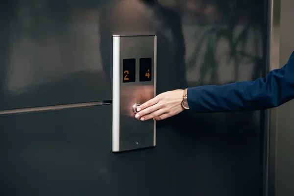 Cropped shot of businesswoman pressing button of elevator — Stock Photo