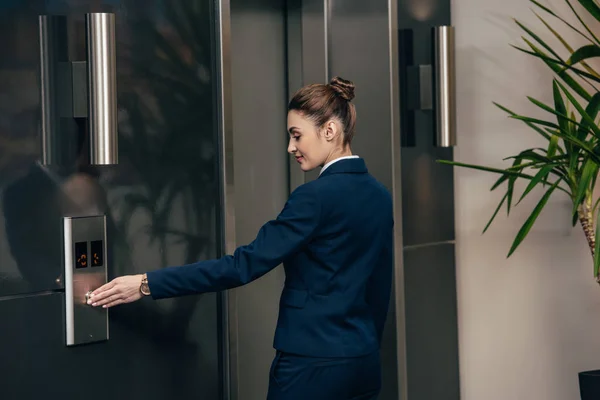 Jovem atraente empresária pressionando botão de elevador — Fotografia de Stock