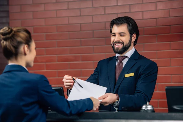 Hotel receptionist showing contract customer at counter — Stock Photo