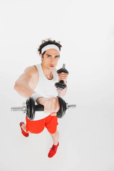 Deportista flaco haciendo ejercicio con pesas aisladas en blanco - foto de stock