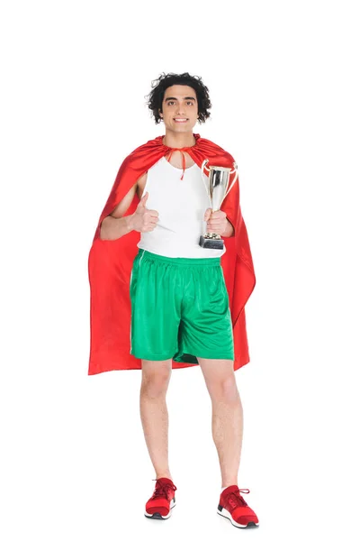 Тонкий спортсмен с трофеем в руках, стоящий в красном плаще изолированный на белом — стоковое фото