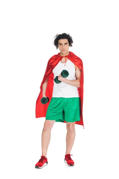 Thin sportsman with dumbbells in hands standing in red cape isolated on white — Stock Photo