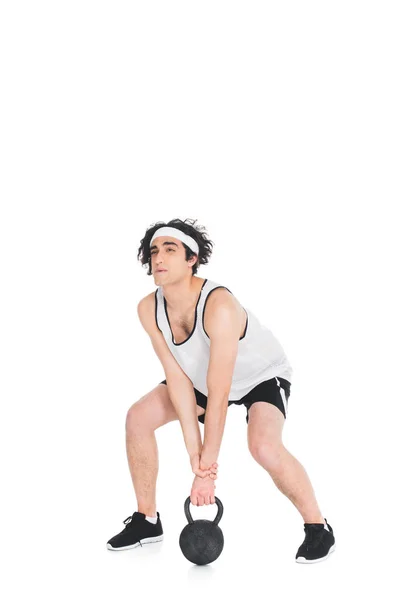 Skinny sportsman raising kettlebell from floor isolated on white — Stock Photo