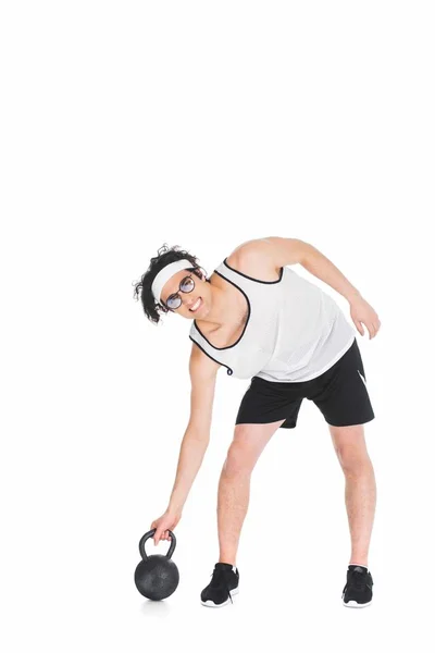 Thin sportsman in eyeglasses raising kettlebell isolated on white — Stock Photo