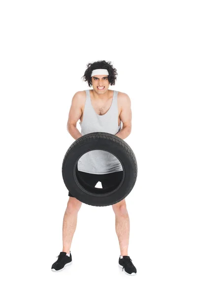 Esportista fino segurando pneu em mãos isoladas em branco — Fotografia de Stock