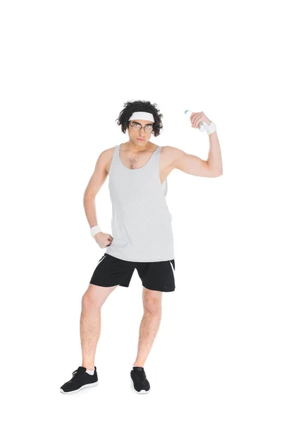Молодой худой спортсмен в очках держит бутылку воды и показывает мышцы, изолированные на белом — стоковое фото
