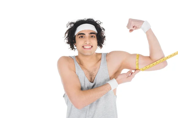 Sonriente deportista delgado midiendo músculos en la mano aislados en blanco - foto de stock