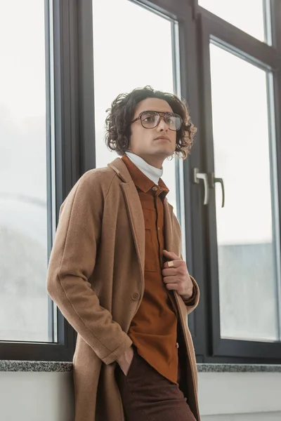 Vista de ángulo bajo de hombre joven con estilo en gafas graduadas - foto de stock