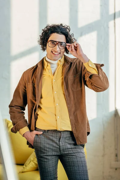 Sonriente modelo de moda masculina sosteniendo gafas - foto de stock