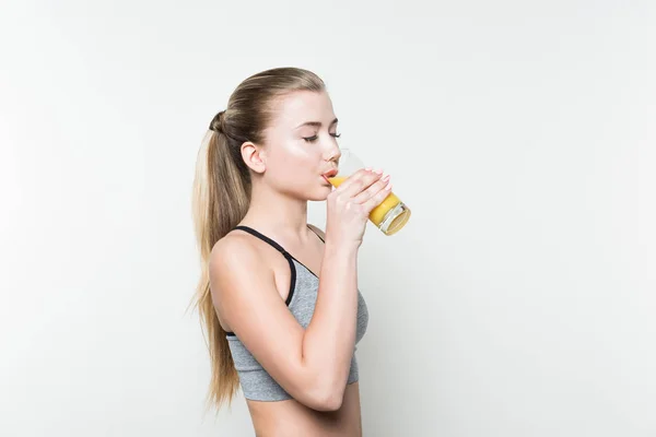 Fit Mädchen trinkt Saft aus Glas isoliert auf weiß — Stockfoto