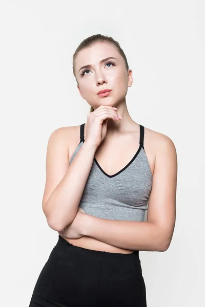 Thoughtful sportswoman with hand on chin isolated on white — Stock Photo