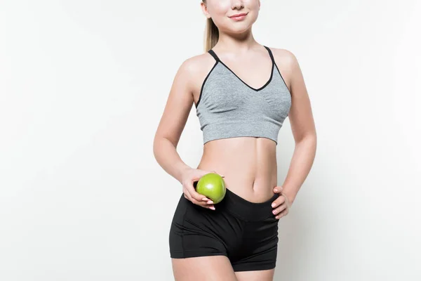 Femme blonde en vêtements de sport tenant pomme isolée sur blanc — Photo de stock