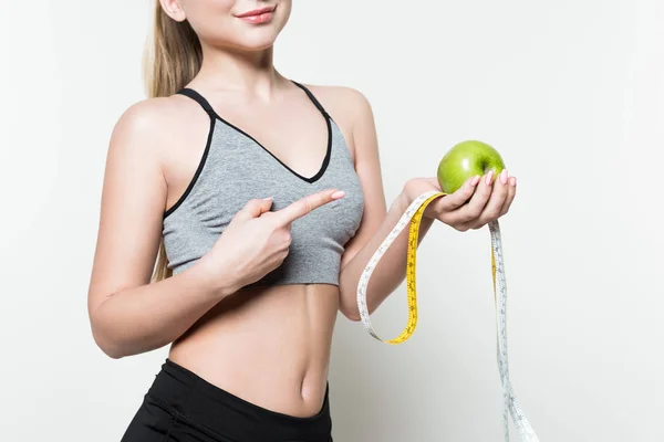 Young girl pointing at apple and measuring tape isolated on white — Stock Photo