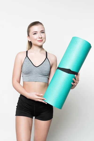 Attractive sportive woman holding yoga mat isolated on white — Stock Photo