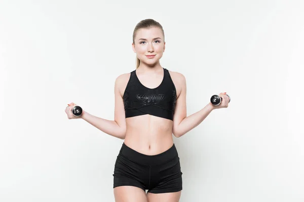 Young woman in sports top lifting dumbbells isolated on white — Stock Photo