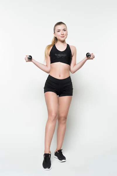 Treinamento de mulher esportiva com halteres isolados em branco — Fotografia de Stock