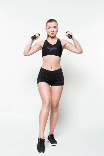 Treinamento de mulher esportiva com halteres isolados em branco — Fotografia de Stock
