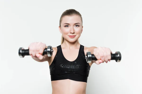 Mulher esportiva exercitando com halteres isolados em branco — Fotografia de Stock