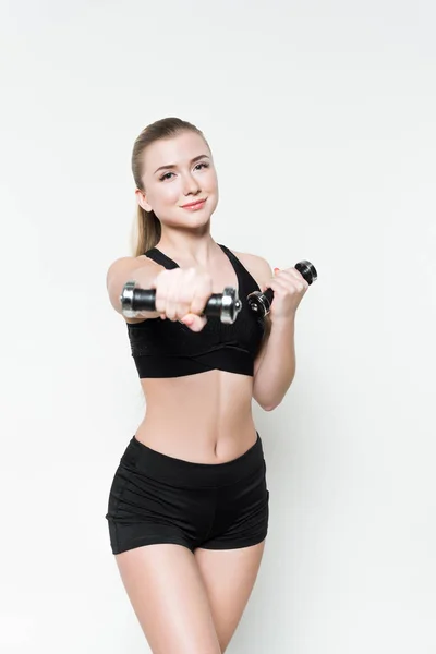 Menina esportiva atraente exercício com halteres isolados em branco — Fotografia de Stock