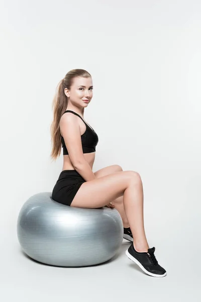 Chica deportiva de entrenamiento en la pelota de ejercicio aislado en blanco - foto de stock