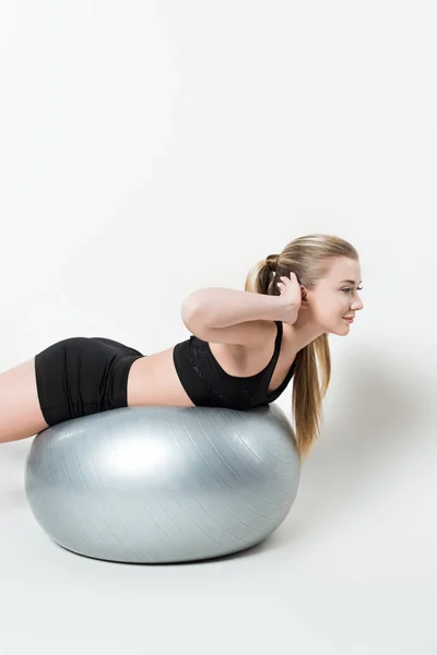 Joven chica en forma de bola de ejercicio aislado en blanco - foto de stock