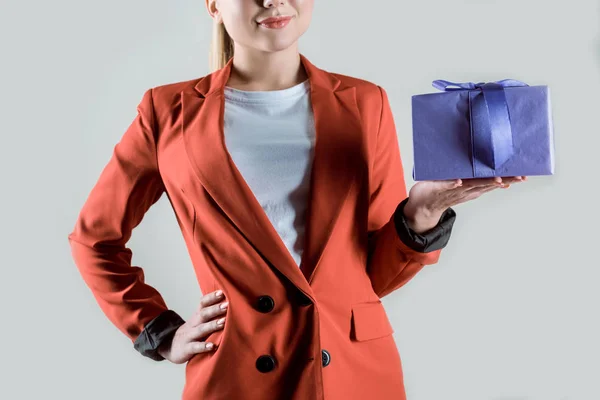 Подарункова коробка в жіночій руці ізольована на сірому — стокове фото