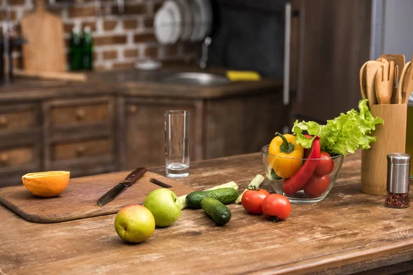 Frutas e legumes orgânicos frescos na mesa de cozinha de madeira — Fotografia de Stock