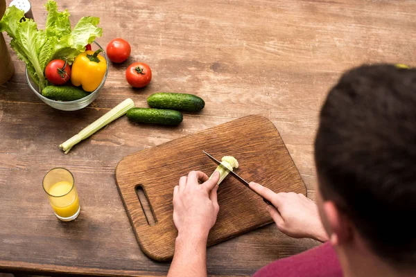 Selective focus of man cutting celery on wooden chopping board — Stock Photo