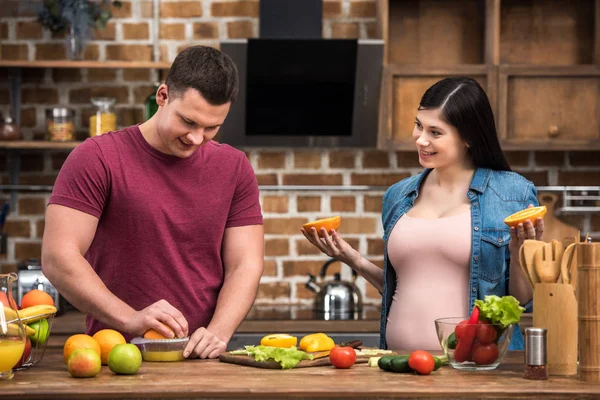 Sourire jeune couple enceinte serrant jus frais ensemble — Photo de stock