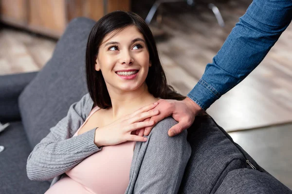 Corte tiro de sorrir jovem grávida olhando para o marido em casa — Fotografia de Stock