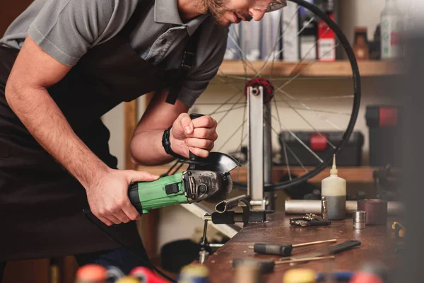 Schnappschuss eines jungen Arbeiters, der in Werkstatt mit dem Winkelschleifer Metall schneidet — Stockfoto