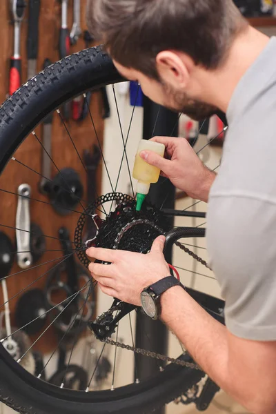 Обрізаний знімок молодого ремонтанта намотування велосипедного ланцюга в майстерні — стокове фото