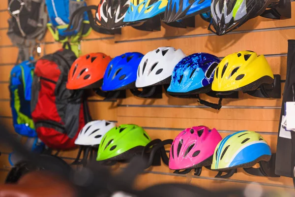 Various colorful helmets displayed in bike shop — Stock Photo