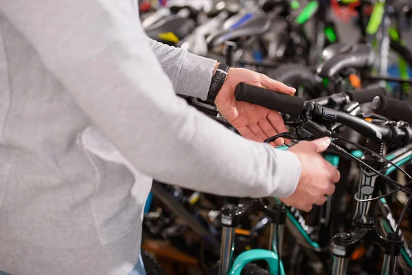 Tiro cortado de homem escolhendo bicicleta na loja de bicicletas — Fotografia de Stock