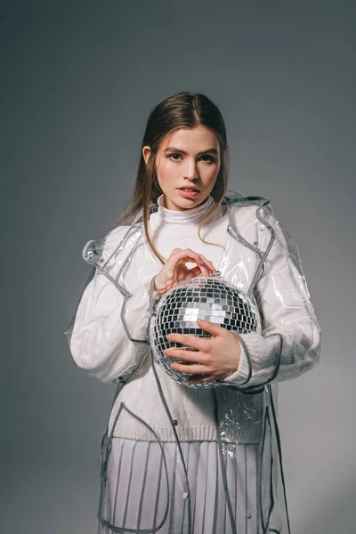 Portrait de jeune femme élégante avec boule disco dans les mains isolées sur gris — Photo de stock