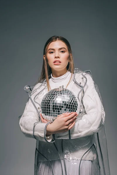 Ritratto di giovane donna elegante con palla da discoteca in mani isolate su grigio — Foto stock