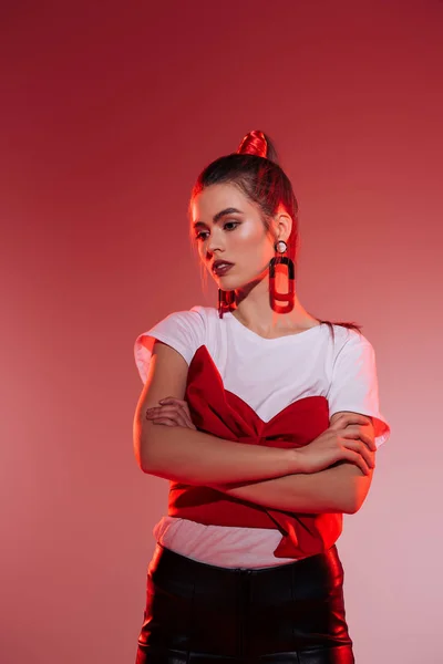 Portrait de la femme à la mode et coûteuse avec les bras croisés regardant loin — Photo de stock