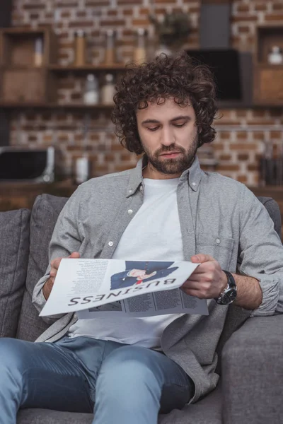 Schöner Mann, der zu Hause Wirtschaftszeitung liest — Stockfoto