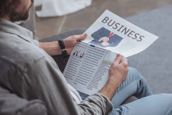 Abgeschnittenes Bild eines Mannes, der zu Hause Wirtschaftszeitung liest — Stockfoto