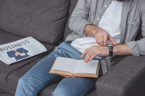 Abgeschnittenes Bild eines Mannes, der zu Hause eine Armbanduhr einstellt — Stockfoto