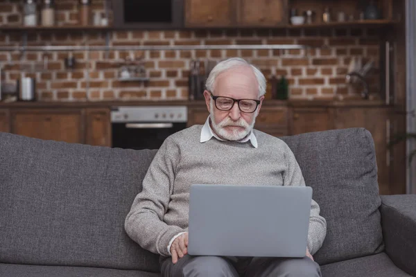 Uomo anziano utilizzando il computer portatile — Foto stock